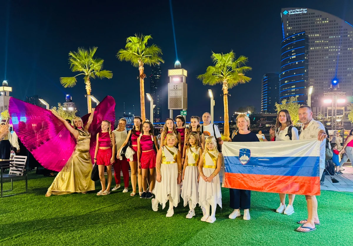 Plesna skupina Arabeska s slovensko zastavo v Dubaju ponoči