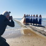Fotograf fotografira plesno skupino Arabeska na pomolu na plaži Lido di Jesolo